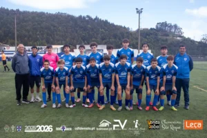 Jogadores de Juvenis Sub-16 do C.D. 1º de Maio, escola de futebol na Madeira, equipados com camisola azul e branca, perfilados em campo na época 2025/2026.