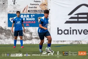 Jogadores de Juvenis Sub-16 do C.D. 1º de Maio, escola de futebol na Madeira, equipados com camisola azul e branca, perfilados em campo na época 2025/2026.
