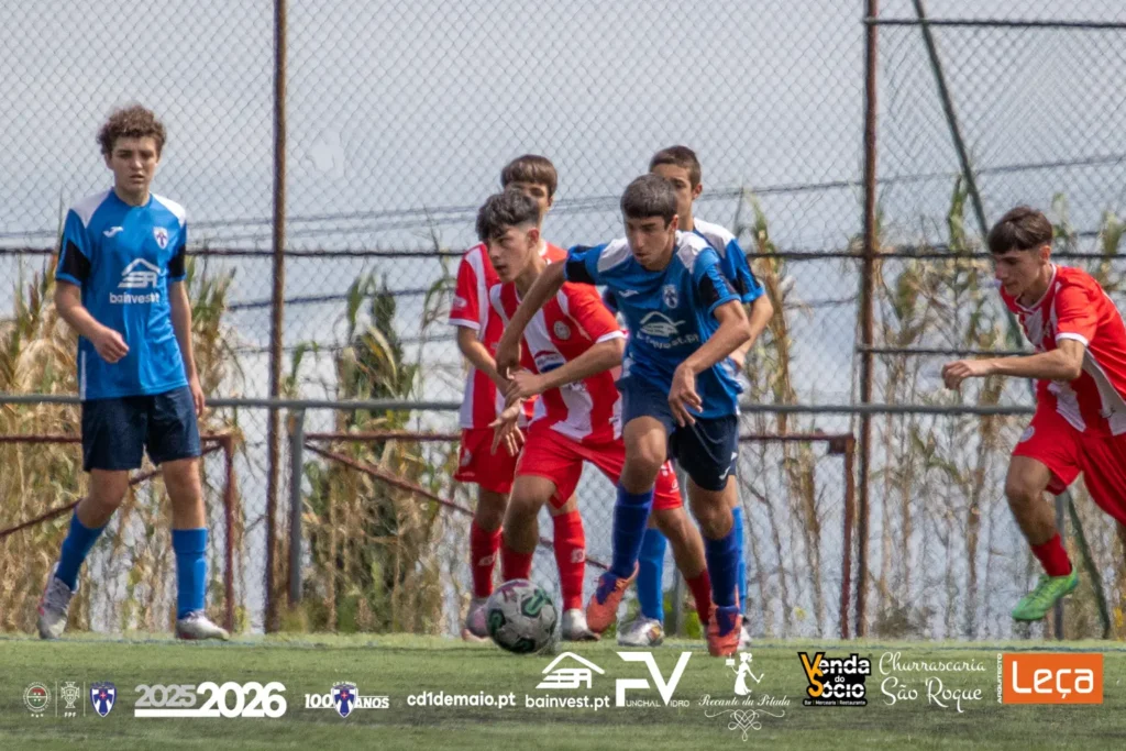 Jogador de Juvenis Sub-16 do C.D. 1º de Maio, escola de futebol na Madeira, focado num jogo oficial da época desportiva 2025/2026.
